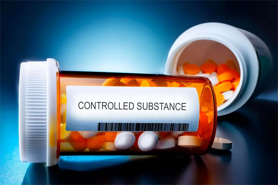 Prescription bottle labeled Controlled Substance highlighting regulation issues.