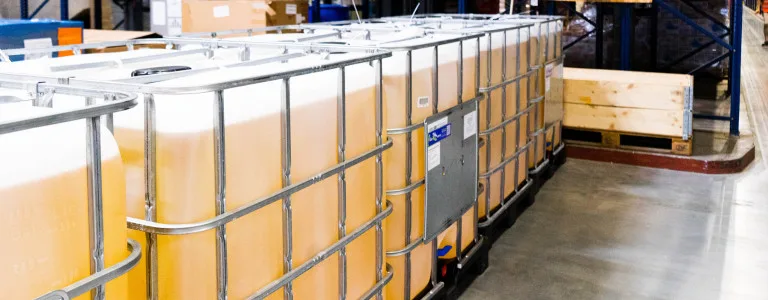Large containers filled with SARMs in storage, illustrating industrial chemical storage solutions in a warehouse setting.