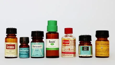Historical pharmaceutical bottles displaying various medication labels for a study on drug development history.